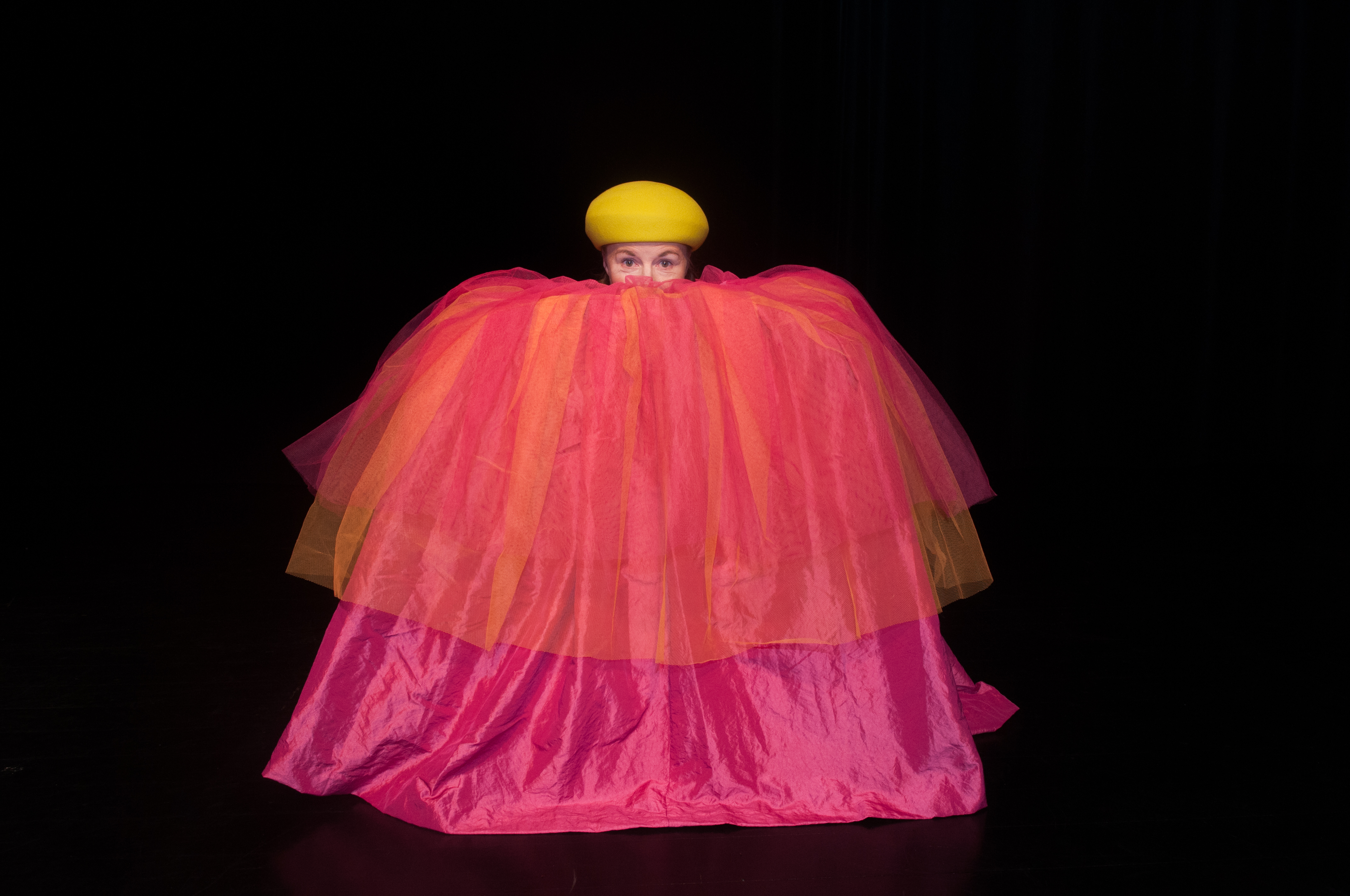 Föreställningsbild, skådespelare i stor rosa klänning och orange mössa