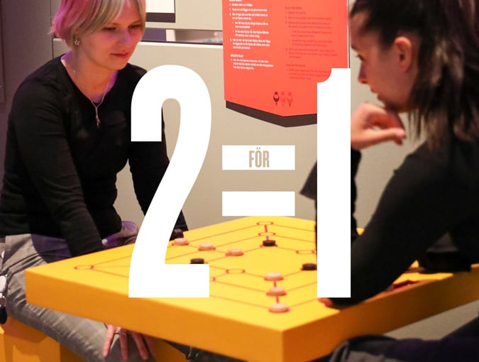 Två personer spelar spel i utställningen Världens spel